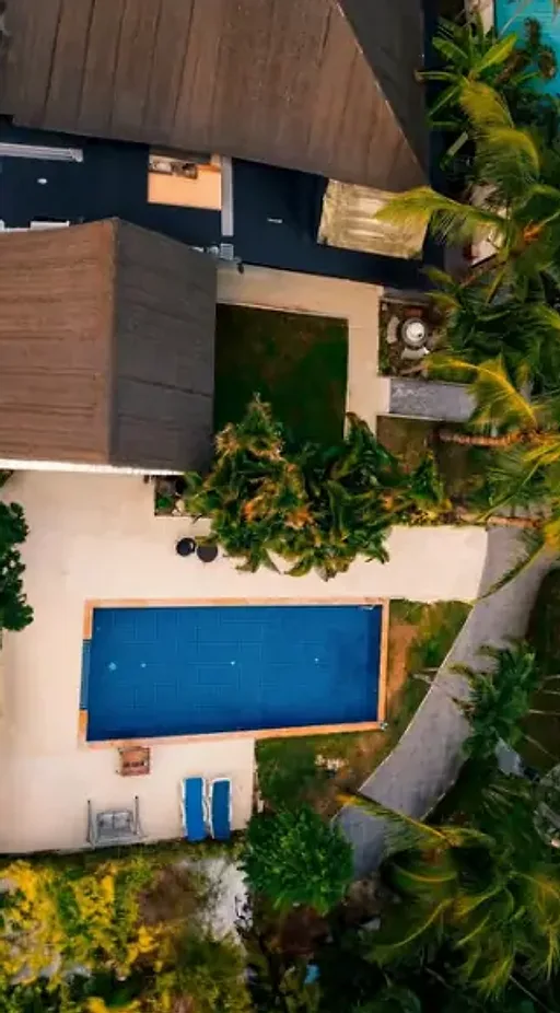 Naya Garden from directly above: cottage roofs, the lawn, the pool and palms