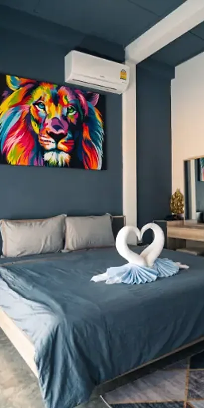 Cottage A bedroom: a bright lion painting above a double bed folded with towel swans