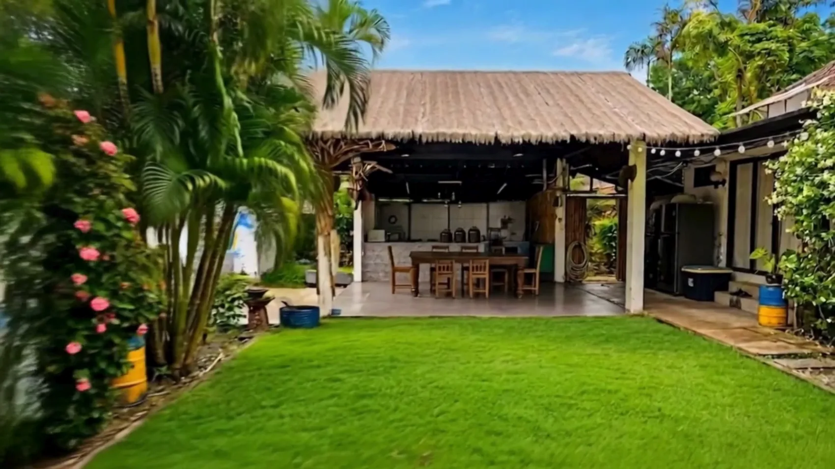 The open-air kitchen at Naya Garden with its thatched roof and long table